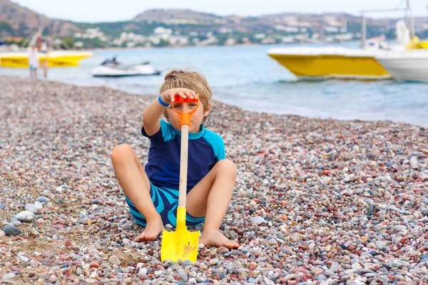 Little kid boy playing on beach with stones — Stock Photo, Image