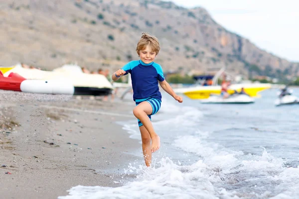 Kleiner blonder Junge läuft am Strand — Stockfoto