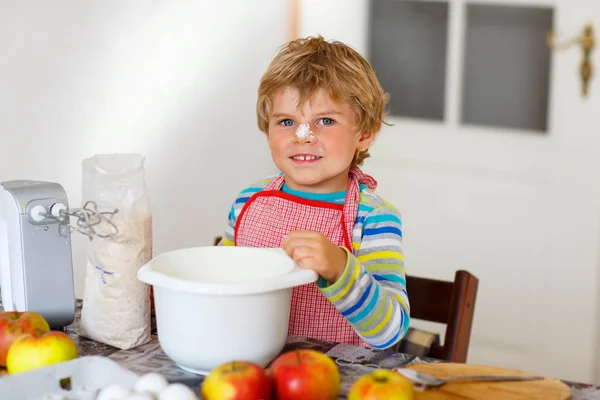 Divertente ragazzo biondo che cuoce torta di mele al chiuso — Foto Stock