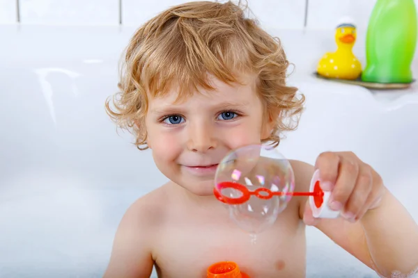 Toddler boy playing with soap bubbles in bathtub — Stock Photo, Image