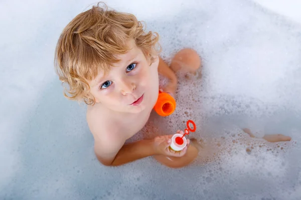 Toddler boy playing with soap bubbles in bathtub — Stock Photo, Image