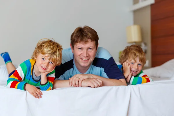 Two little sibling kid boys and dad having fun in bed after slee — Stock Photo, Image