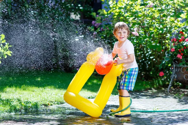 Bir bahçe hortumu ile oynarken küçük çocuk çocuk — Stok fotoğraf