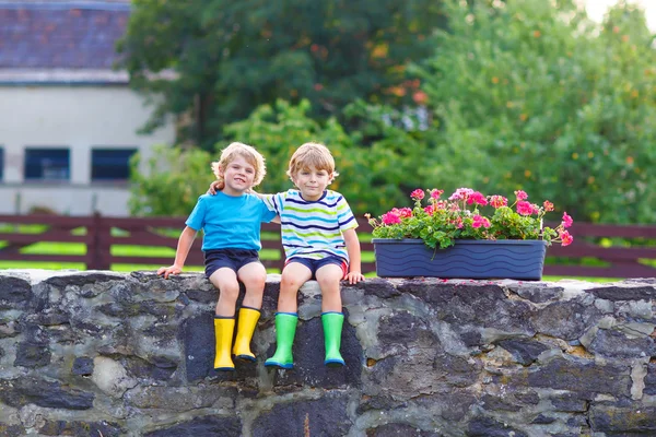 Two little kid boys sitting together on stone bridge — Stock Photo, Image