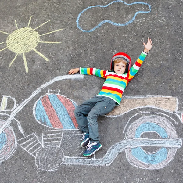Little child in helmet with motorcycle picture drawing with colo — Stock Photo, Image