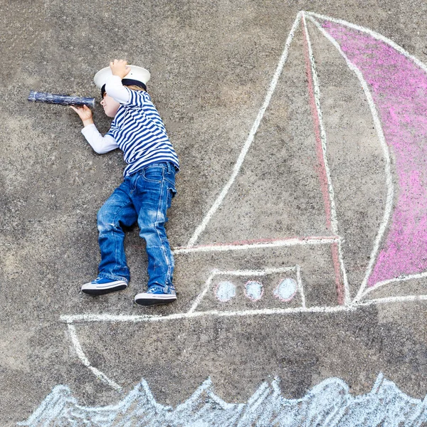 Kleine jongen met plezier met schip afbeelding tekenen met krijt — Stockfoto