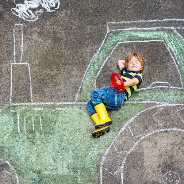 Little boy having fun with tractor picture drawing with chalk — Stock Photo, Image