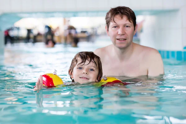 Little kid boy and his father swimming in an indoor pool — Stok fotoğraf