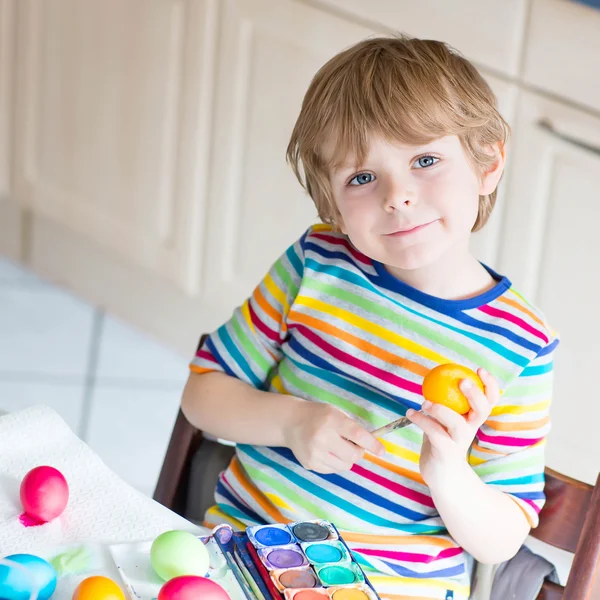 Liten unge pojke färgning ägg till påsk — Stockfoto