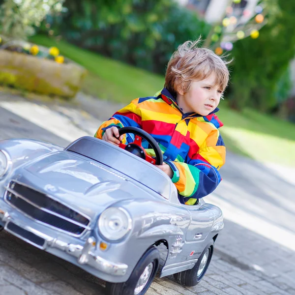 Pequeño niño preescolar conduciendo un gran juguete viejo coche vintage, al aire libre —  Fotos de Stock