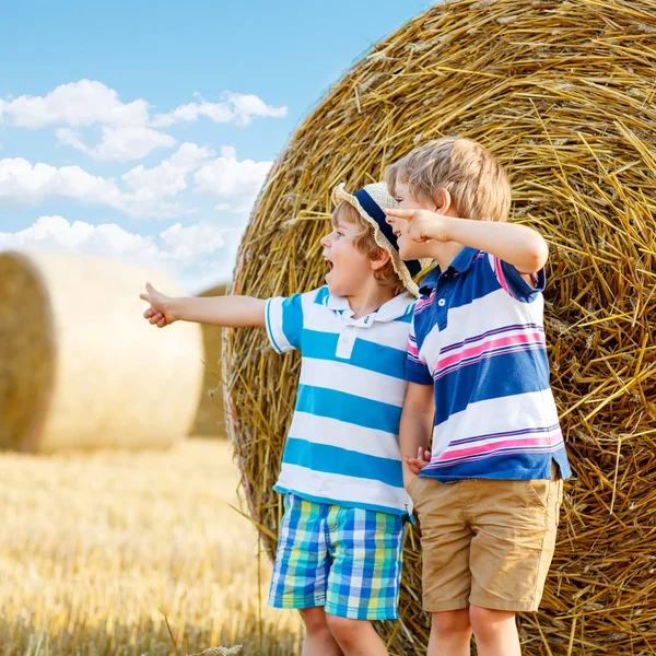 Deux petits enfants et amis avec une meule de foin ou une balle — Photo