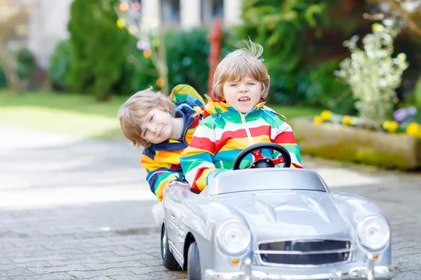 Deux garçons heureux frères et sœurs jouant avec une grande vieille voiture jouet — Photo