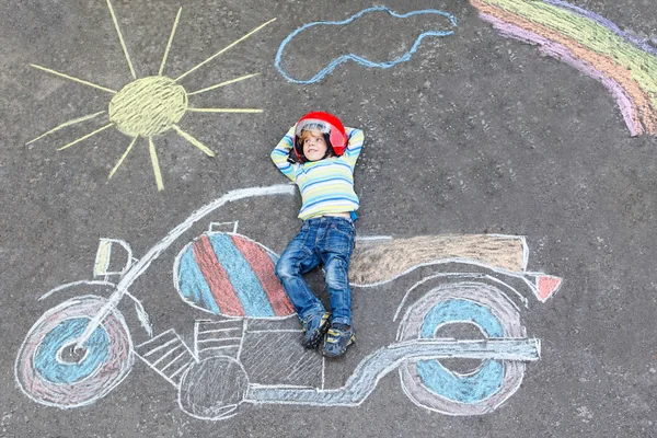 Litet barn i hjälm med motorcykel bild ritar med colo — Stockfoto