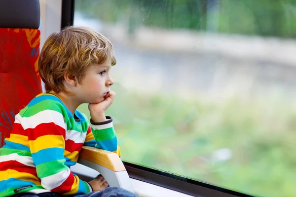 Little boy sitting in train and going on vacations — Zdjęcie stockowe