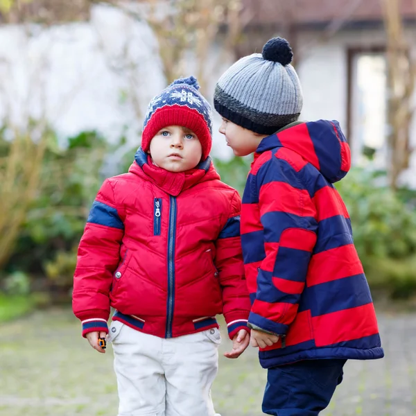 Two little kid boys walking together outdoors. — 图库照片