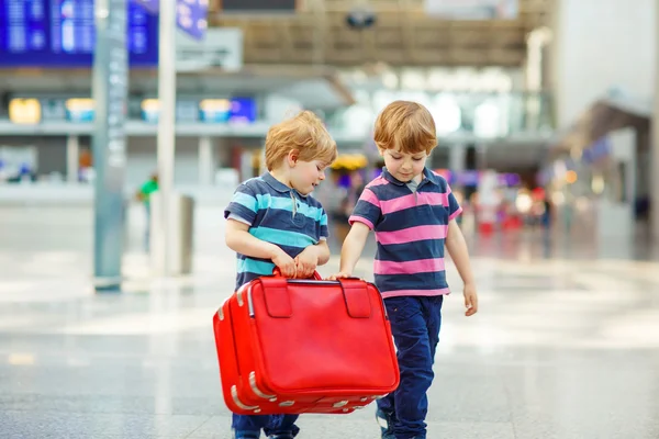 Two tired little sibling boys at the airport — Stock fotografie