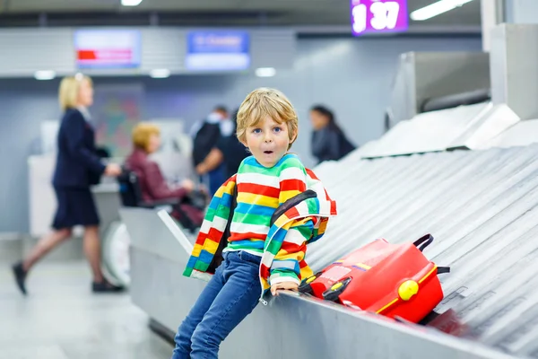 Маленький втомлений хлопчик в аеропорту, подорожує — стокове фото