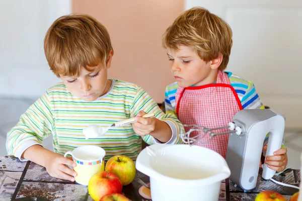 Двоє маленьких хлопчиків випікають яблучний торт у приміщенні — стокове фото