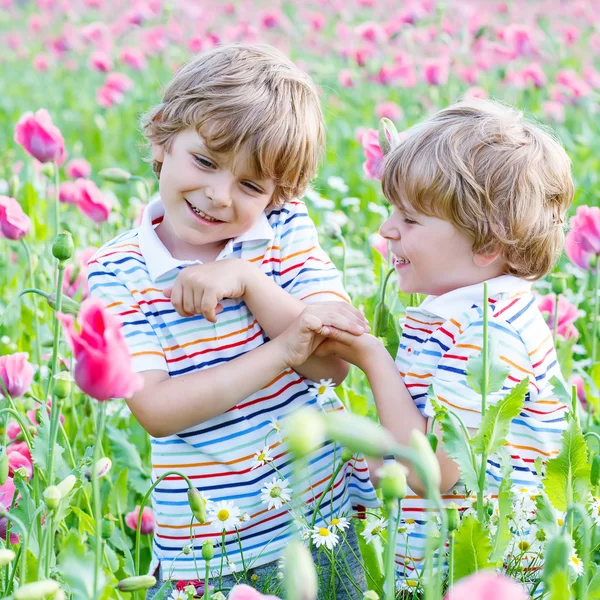 Dwa szczęśliwy blond dzieci w kwitnienia Mak pole — Zdjęcie stockowe