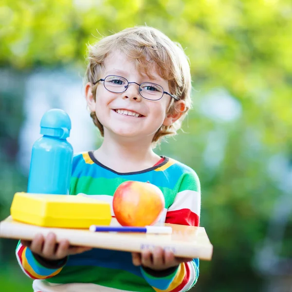 Niño de la escuela feliz con libros, manzana y botella de bebida — Foto de Stock