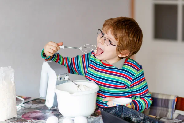 Grappige blonde jongen jongen binnenshuis taart bakken — Stockfoto