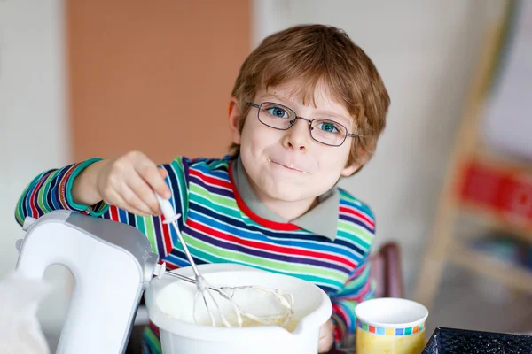 Divertido chico rubio hornear pastel en el interior — Foto de Stock