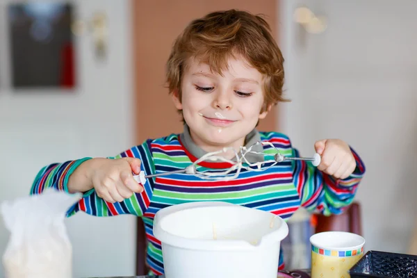 Divertente ragazzo biondo che cuoce torta al chiuso — Foto Stock