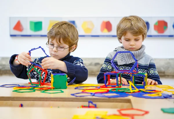 Två kid lite pojkar bygga geometriska figurer — Stockfoto