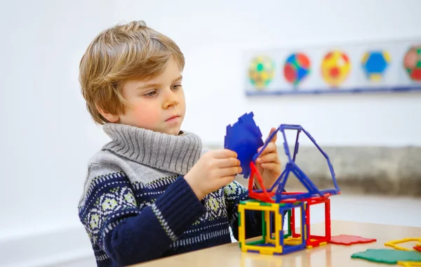 Jongetje kind geometrische figuren met kunststof blokken bouwen — Stockfoto