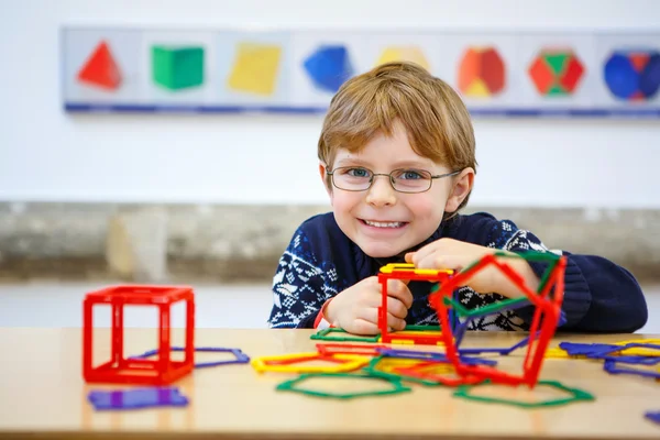 Jongetje kind geometrische figuren met kunststof blokken bouwen — Stockfoto