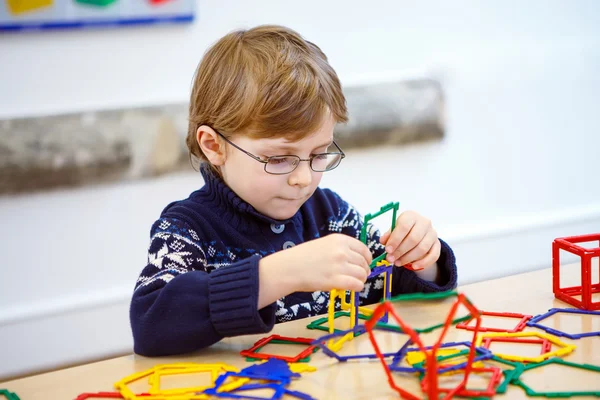 Mały chłopiec dziecko Budowanie figur geometrycznych z plastikowych klocków — Zdjęcie stockowe