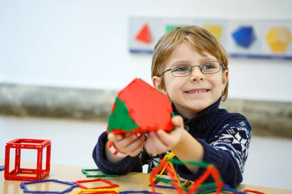 Kis gyerek fiú épület geometriai ábrák műanyag blokkok — Stock Fotó