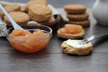 Yulaf çörekler tereyağı ve armut ile koyu ahşap arka plan reçel