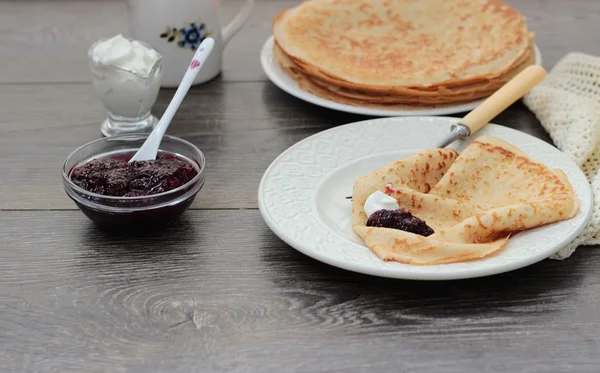Stack of pancakes served with berry jam and sour cream — Stock Photo, Image