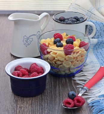 Sağlıklı kahvaltı. Kâse Mısır gevreği yemek ve ahşap zemin üzerine dökülen süt taze çilek ile