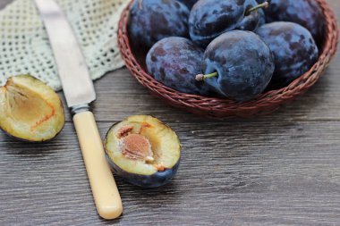 Eski ahşap arka planda bir kasede taze erikler