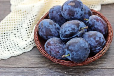 Eski ahşap arka planda bir kasede taze erikler