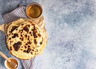 Ballı ve bitkisel çaylı ev yapımı çıtır ekmek, mavi arka plan. Üst görünüm.