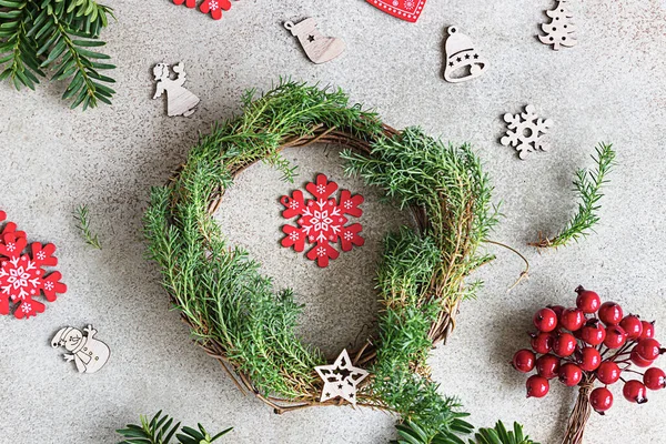 Traditional Christmas wreath with decorative berries and wooden Christmas toys. Christmas and winter holidays celebration concept. Top view.