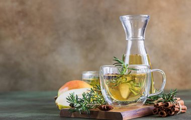 Bardaklar sıcak armut ya da elma şırası ile Noel ya da yeni yıl için. Geleneksel sonbahar ya da kış içeceği biberiye, tarçın ve anason ile. Yeşil beton arka plan. Seçici odak.