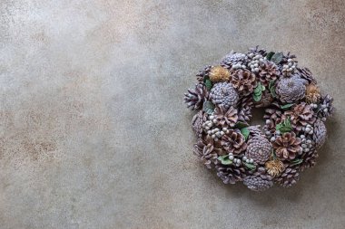 Köknar kozalaklarından yapılmış Noel çelengi. Doğal malzemelerle yapılmış bir çelenk. Noel ve yeni yıl tatilleri. Kış tatili geleneği.