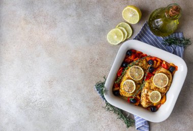 Fırında pişirilmiş veya ızgara tavuk göğsü fırında dolmalık biber, limon ve zeytin, açık beton arka plan. Sağlıklı yemek..