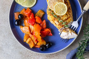 Fırında pişirilmiş veya ızgara tavuk göğsü fırında dolmalık biber, limon ve zeytin, açık beton arka plan. Sağlıklı yemek..