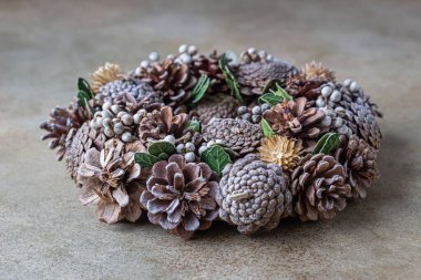 Köknar kozalaklarından yapılmış Noel çelengi. Doğal malzemelerle yapılmış bir çelenk. Noel ve yeni yıl tatilleri. Kış tatili geleneği.