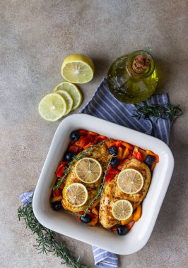 Fırında pişirilmiş veya ızgara tavuk göğsü fırında dolmalık biber, limon ve zeytin, açık beton arka plan. Sağlıklı yiyecekler. Üst görünüm.