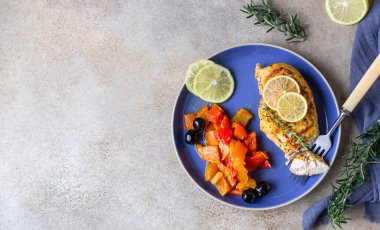 Fırında pişirilmiş veya ızgara tavuk göğsü fırında dolmalık biber, limon ve zeytin, açık beton arka plan. Sağlıklı yiyecekler. Üst görünüm.