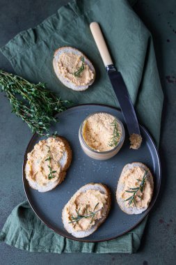 Füme somonlu sandviç ve krem peynirli börek ya da kekik ve biberiyeli krema seramik tabakta, yeşil beton zemin. Seçici odaklanma. Üst görünüm.