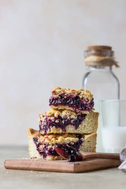 Ev yapımı böğürtlen reçeli kısayol kareleri ve bir bardak süt, açık beton arka plan.