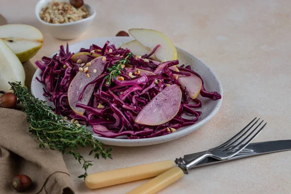 Красная капуста, груша и ореховый салат с соусом из лимона и оливкового масла. Светлый каменный фон. Вегетарианская еда. — стоковое фото