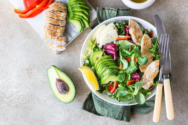 Avocado, apple, bell pepper and grilled chicken salad with ingredients for making salad. Paleo and keto diet. Top view. — Stock Photo, Image